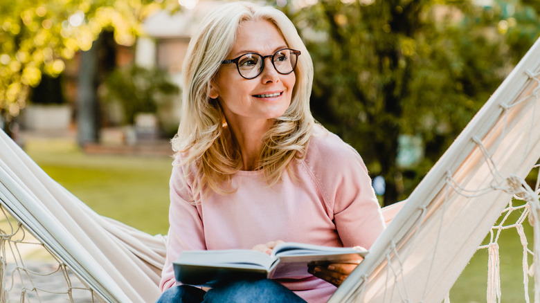 Woman sitting on hammock reading 