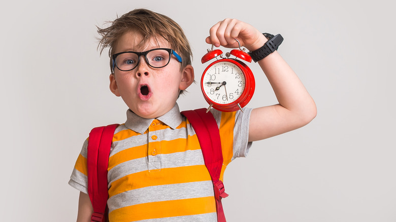 boy holding alarm clock 