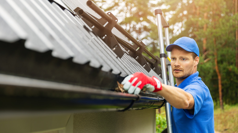 Man cleaning gutters 