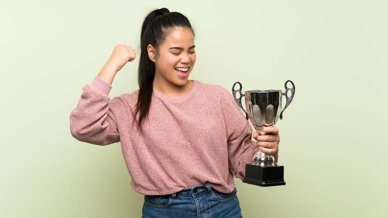 Teen girl holding a trophy 