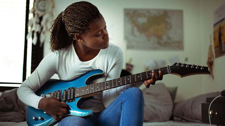 Teen girl playing guitar 