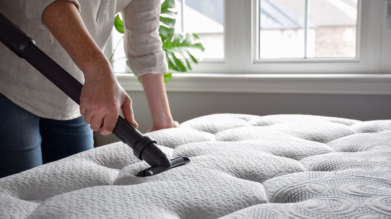 Person vacuums mattress