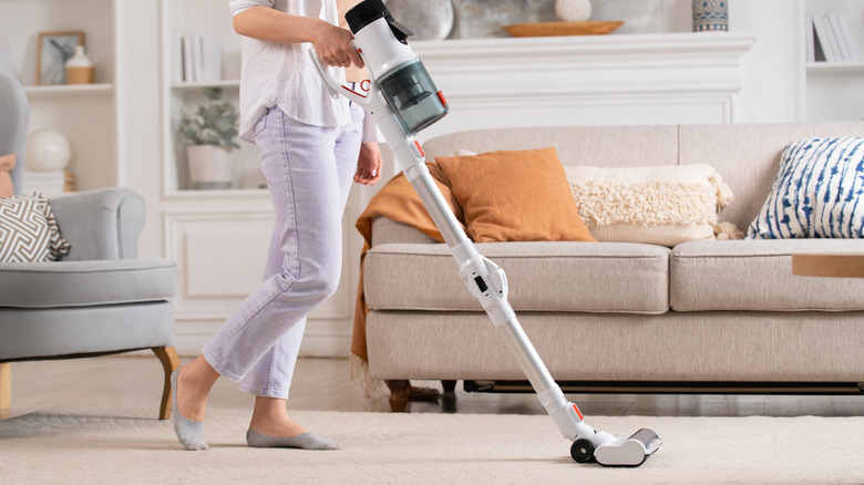 woman vacuuming beige carpet