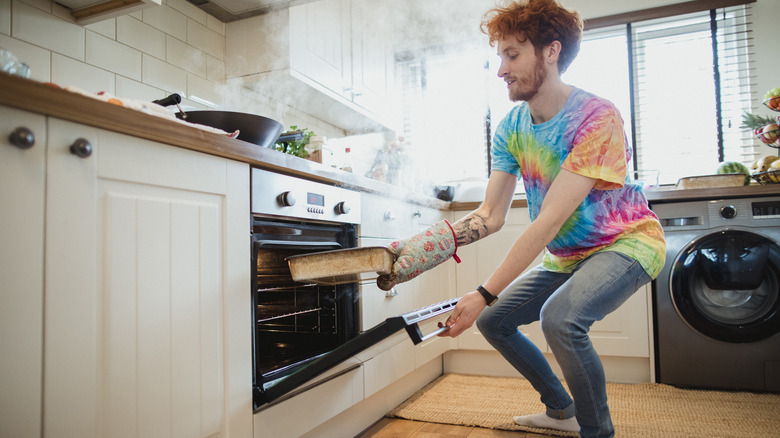 Man holding steaming pan 