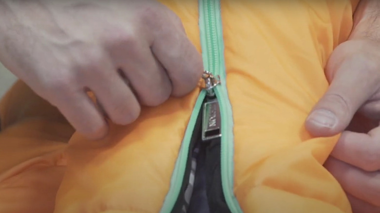 man fixing jammed zipper