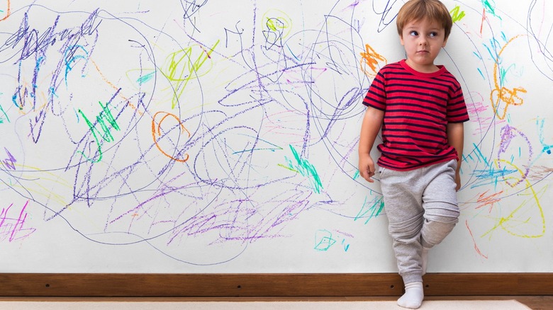 Kid standing against colored walls 