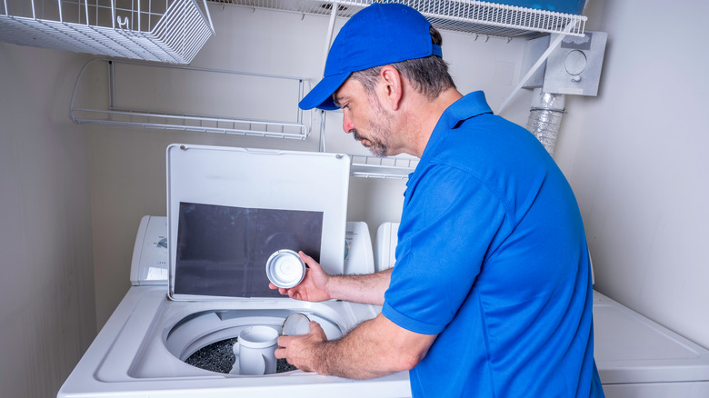 Man taking apart agitator in washing machine