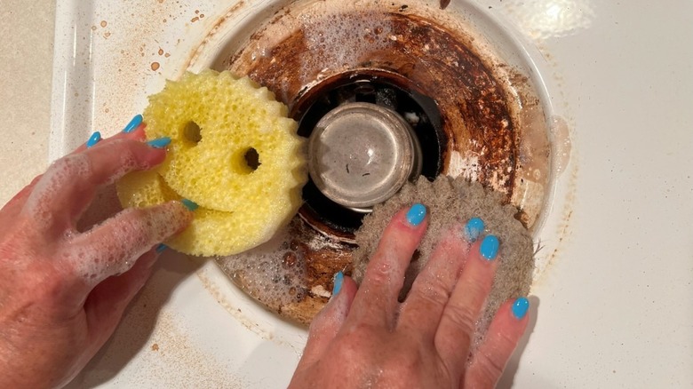 scrubbing stovetop with Scrub Daddys