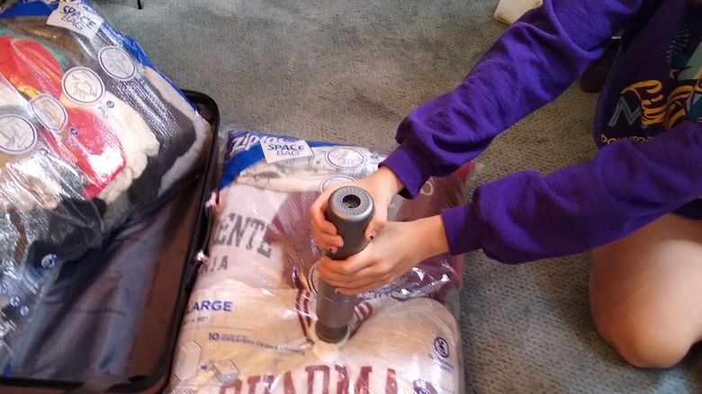 woman vacuuming air from bag