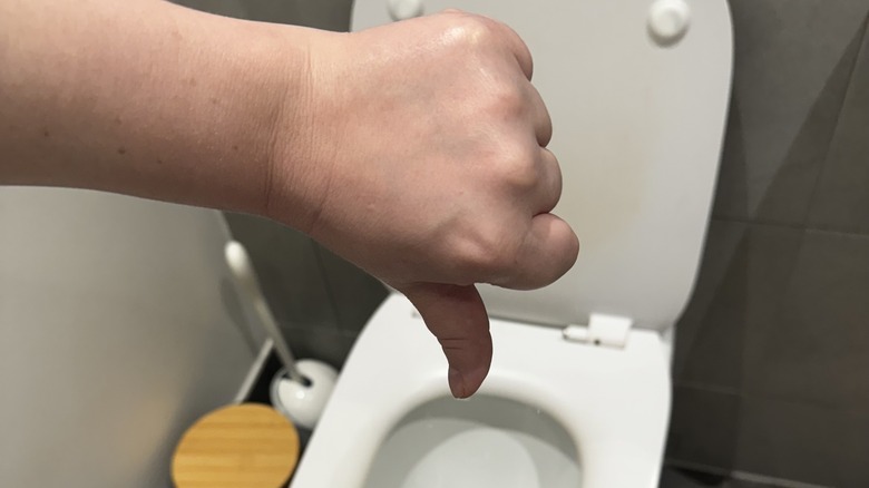 Thumbs down by toilet