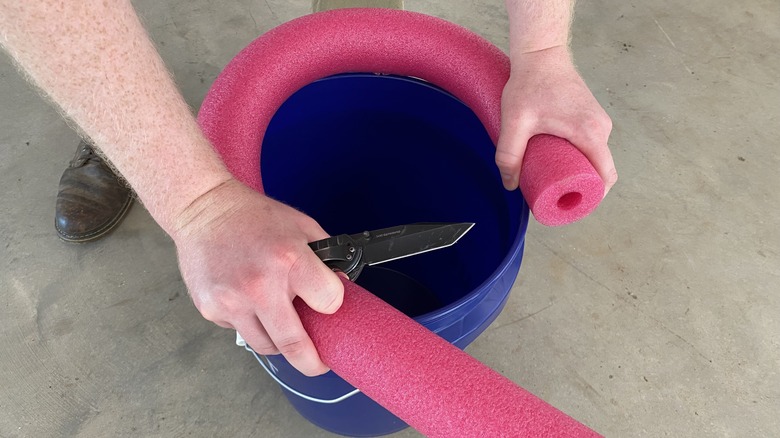 Hands wrapping noodle around bucket