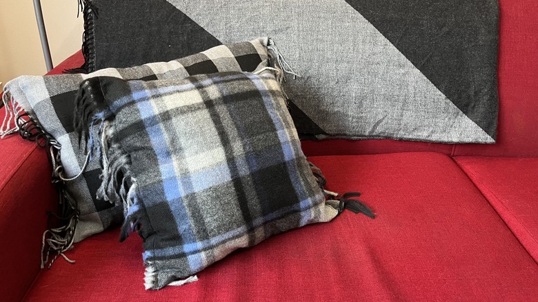 Two plaid cushions on a red couch