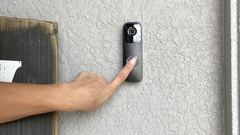 pressing smart doorbell at entry