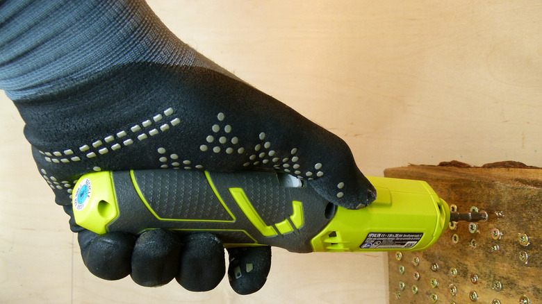 Gloved hand using screwdriver