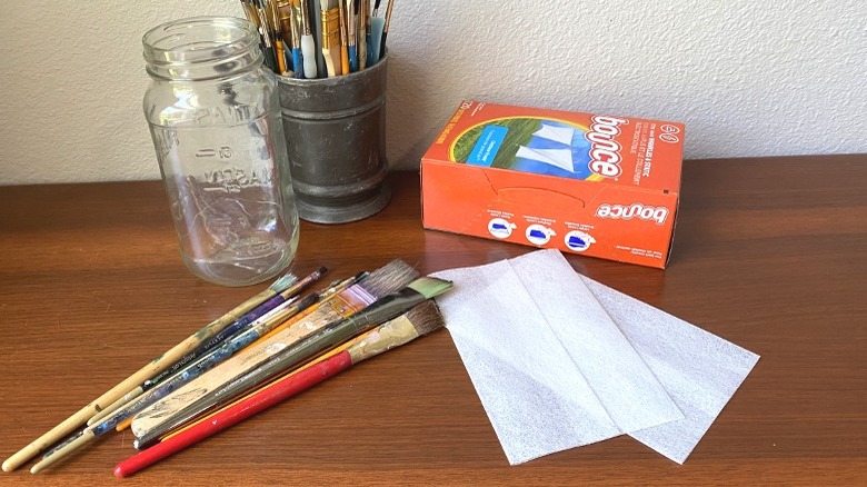 Paintbrushes, dryer sheets, glass jar