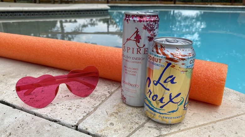 Canned drinks and sunglasses by pool