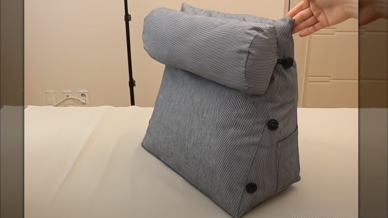 Hand holding a wedge pillow