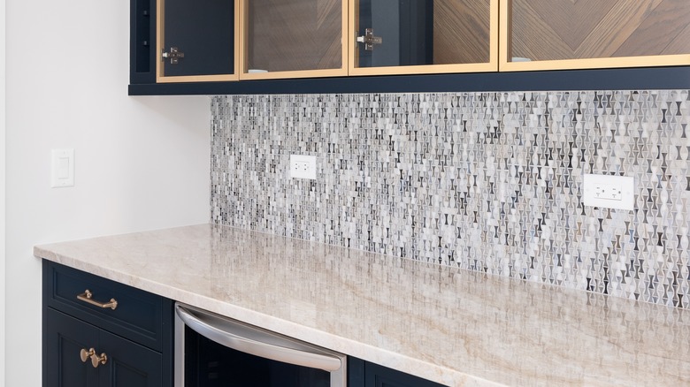 Small patterned tile backsplash on backsplash of home bar area