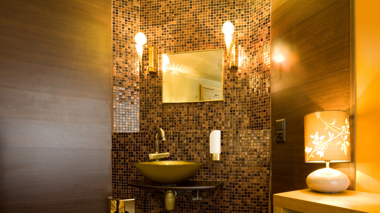 Warm bathroom with small tile patterns behind sink and mirror