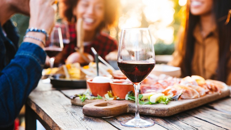 Friends having wine and snacks outdoors