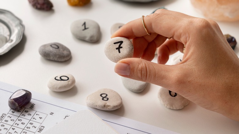Hand holding stones with numbers