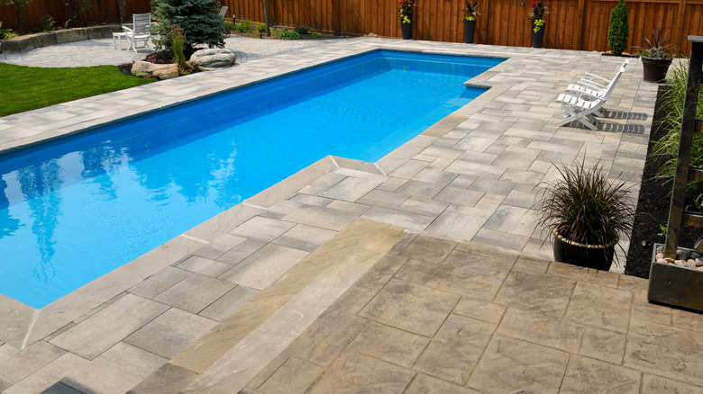 Paved patio around pool in garden