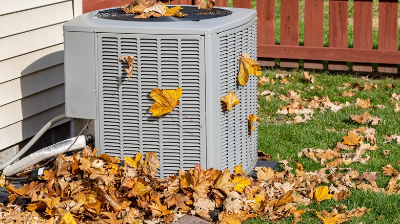 outdoor air conditioner unit with leaves