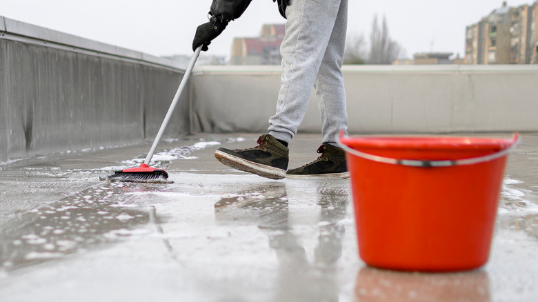 Using rubber broom to clean patio