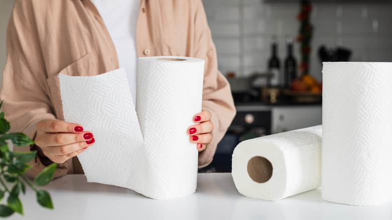 Woman holding paper towel roll in kitchen