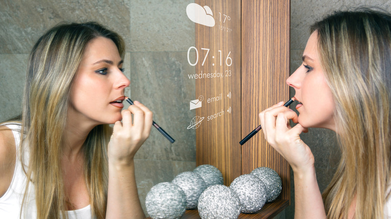 Woman doing makeup in mirror