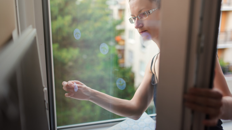 Woman puts on window decal