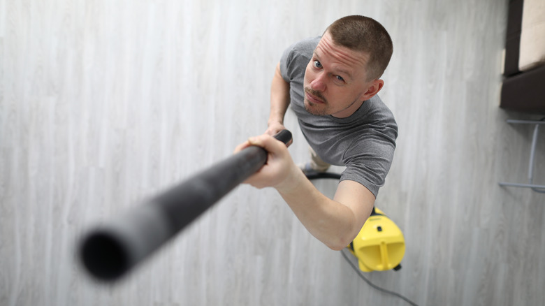 man holding vacuum attachment