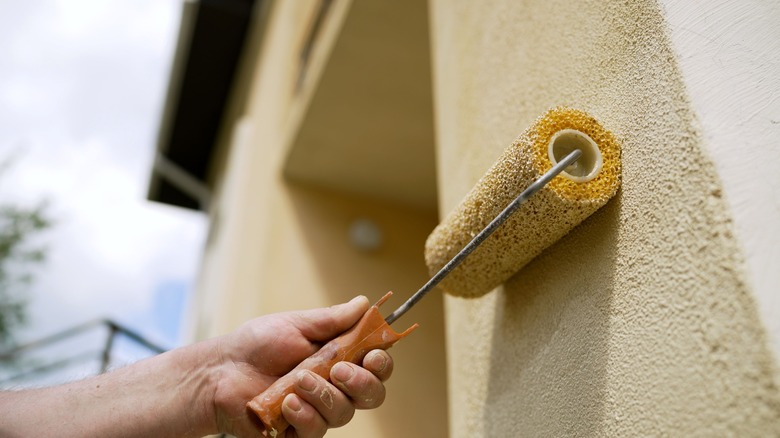 worker painting exterior wall