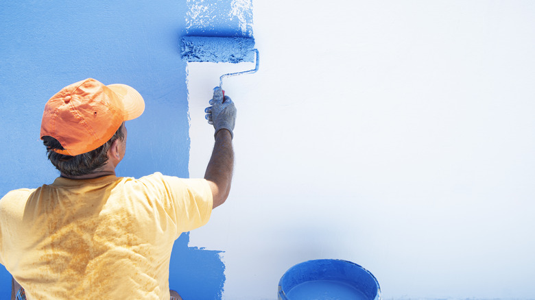 Person painting room blue