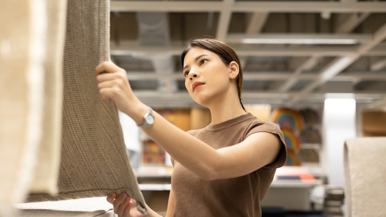 woman choosing rug at store