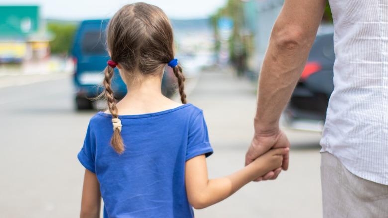 Girl and man holding hands