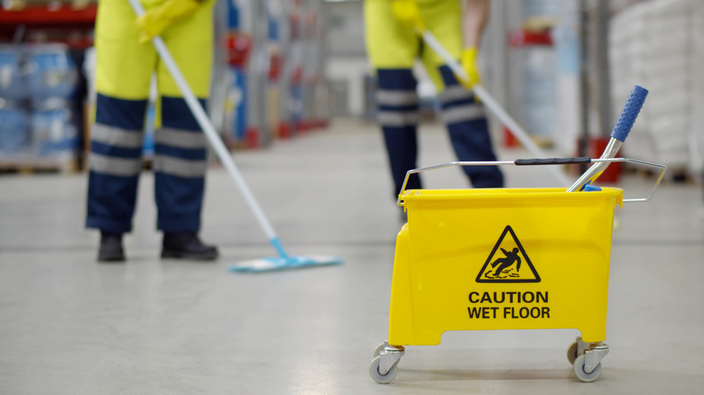 Two people mopping wet floor