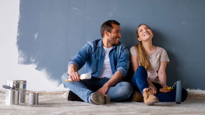 couple leaning against repainted wall