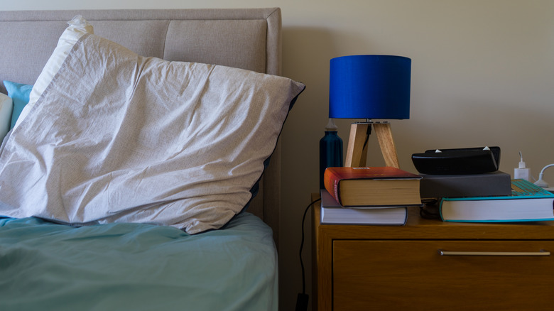 Wrinkled pillow by messy nightstand