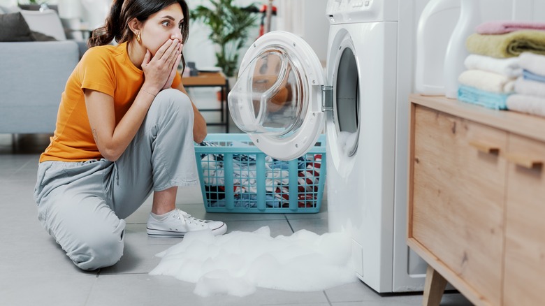 Woman next to overflowing washer