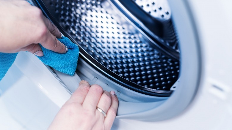 closeup of cleaning inside of washer with blue cloth