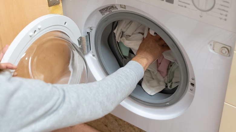 woman filling laundry machine drum