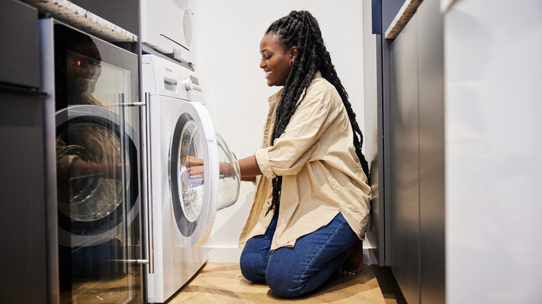 woman putting clothes in dryer