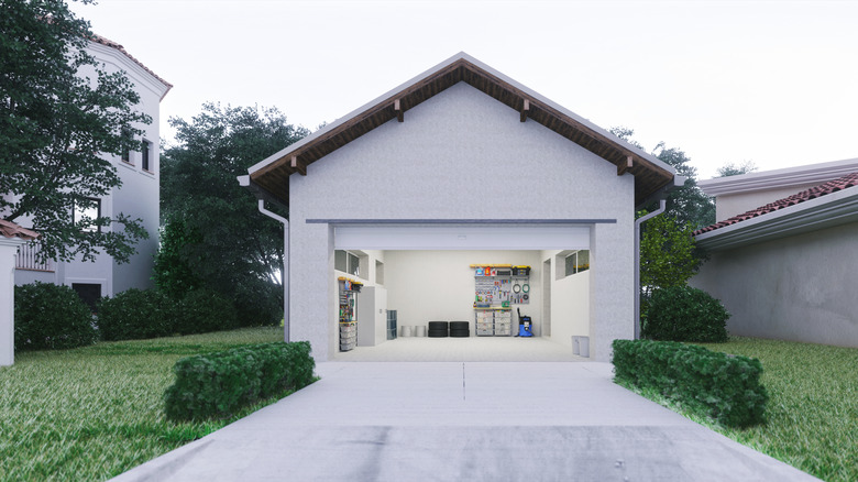 The view of an open garage and driveway from an unfenced front yard