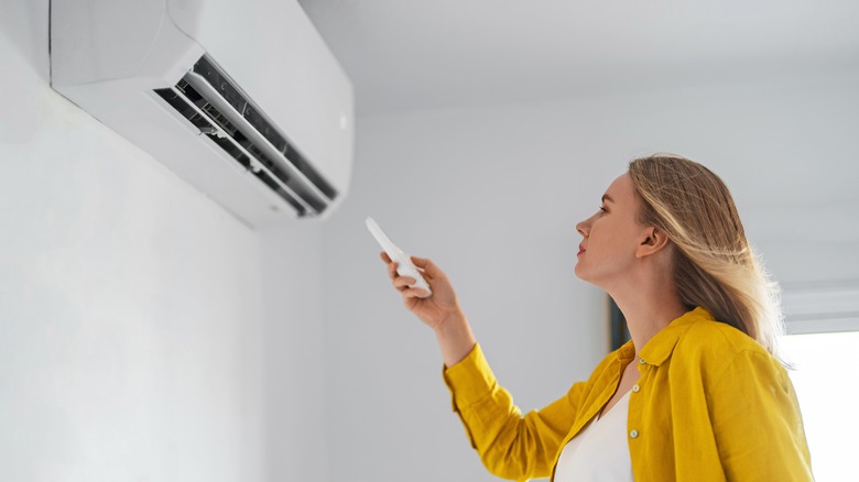 woman controlling air conditioner