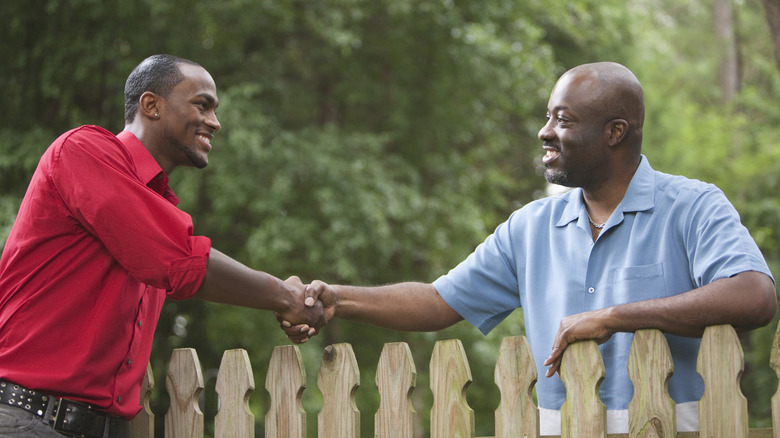 Man building wooden fence with drill