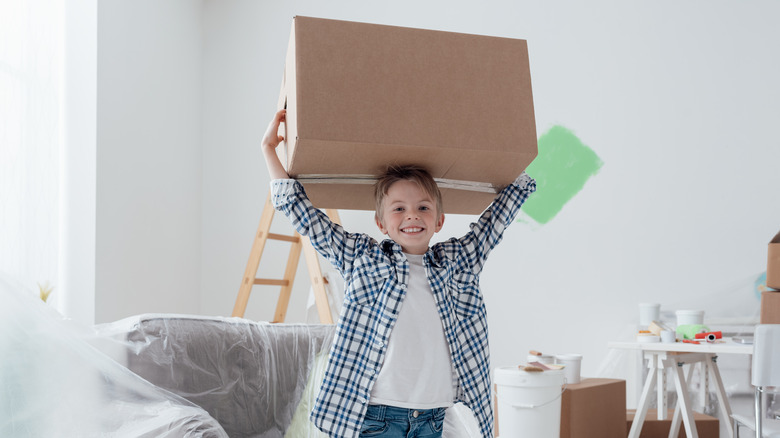 small boy lifting big box