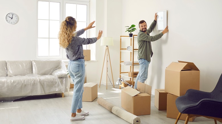 couple hanging a picture frame