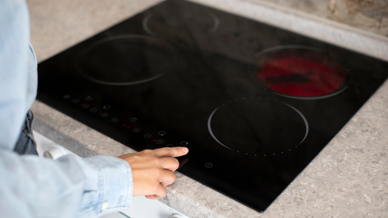 Person turns on an electric hob