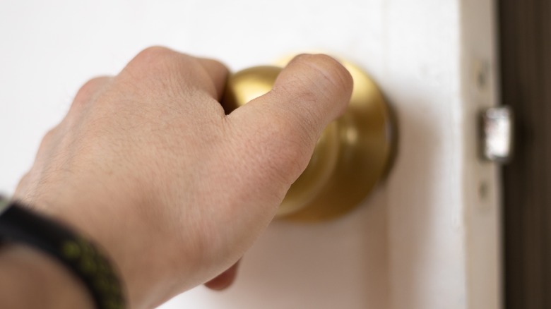 Hand on gold door knob